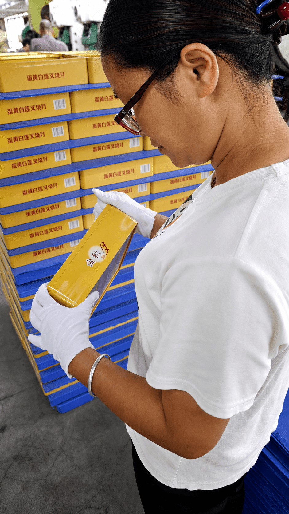 Quality inspector examining a finished tin container by hand